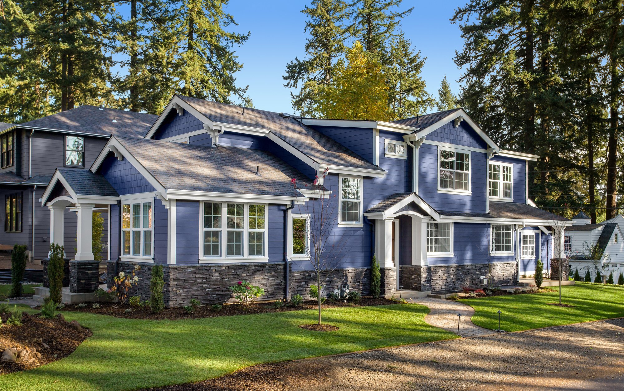 Beautiful luxury home exterior on bright sunny day with green grass and blue sky